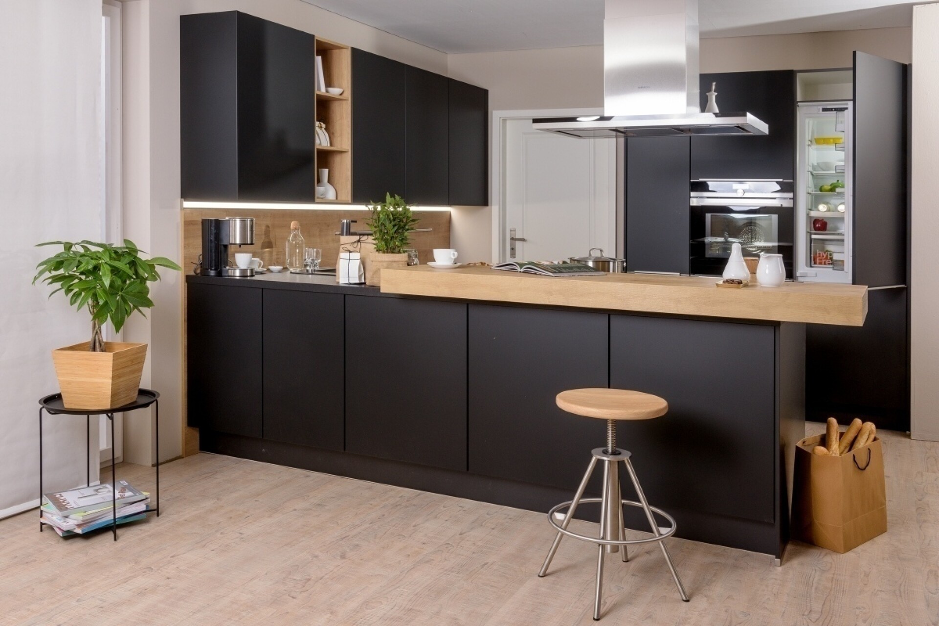 Schwarzes Küchendesign mit freistehender Küchentheke, die auch als Esstheke fungiert