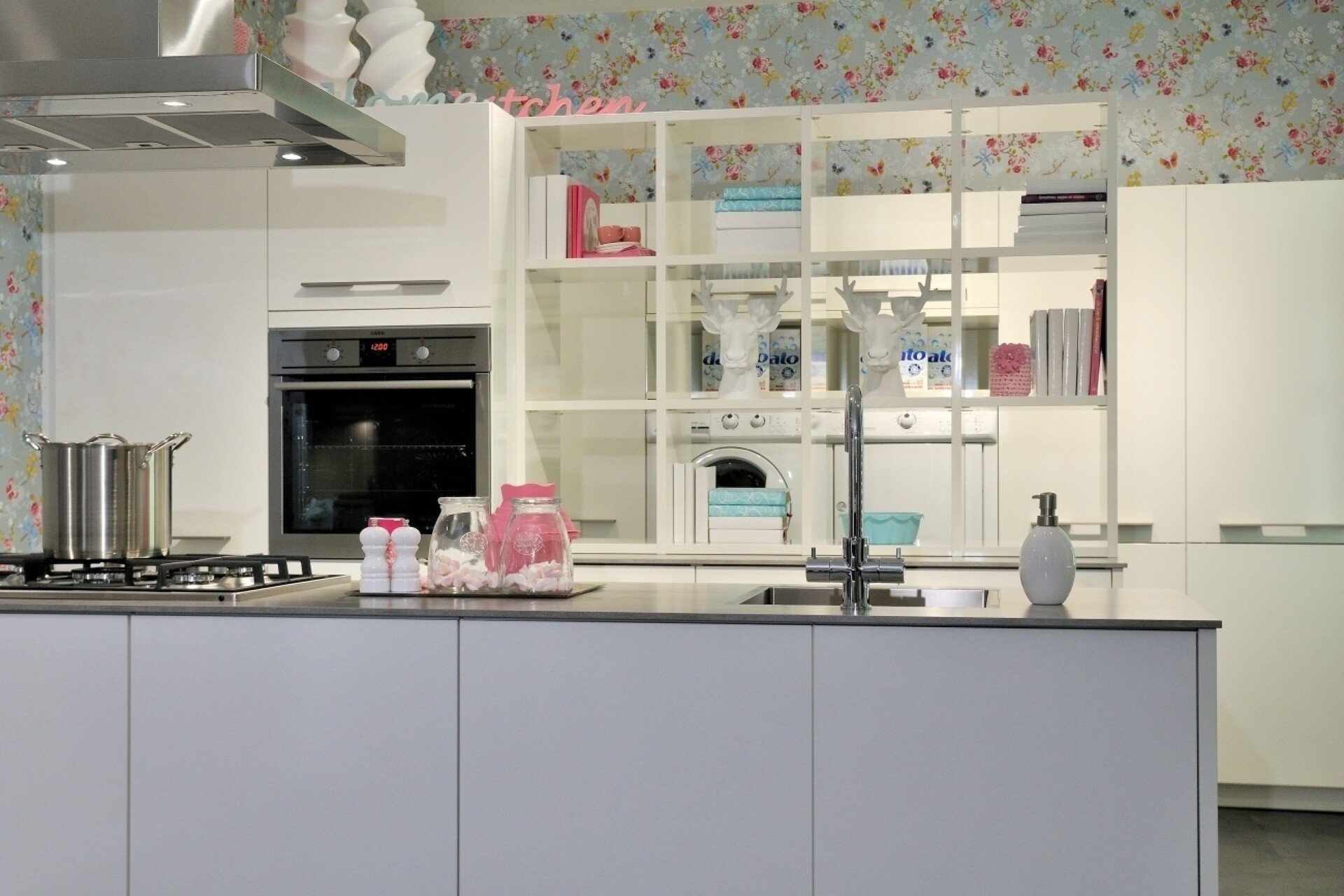 Die freistehende Theke, grifflos und matt lackiert, schafft eine ruhige Barriere zum Küchenbereich.